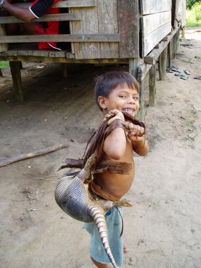 Boy returns from the hunt with armadillo (tatu), Brazilian Amazon