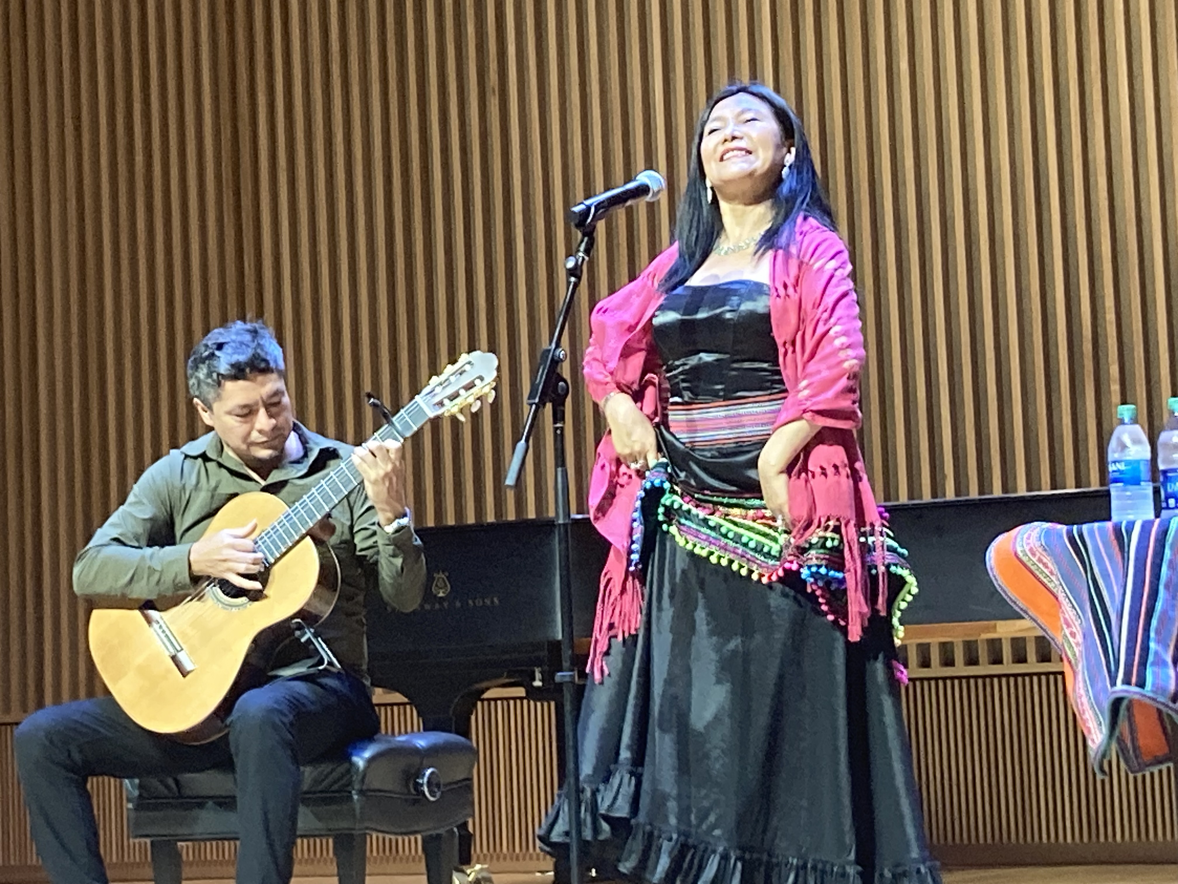 Coco Vega (left) plays guitar and Consuelo Jerí (right) dances during a performance