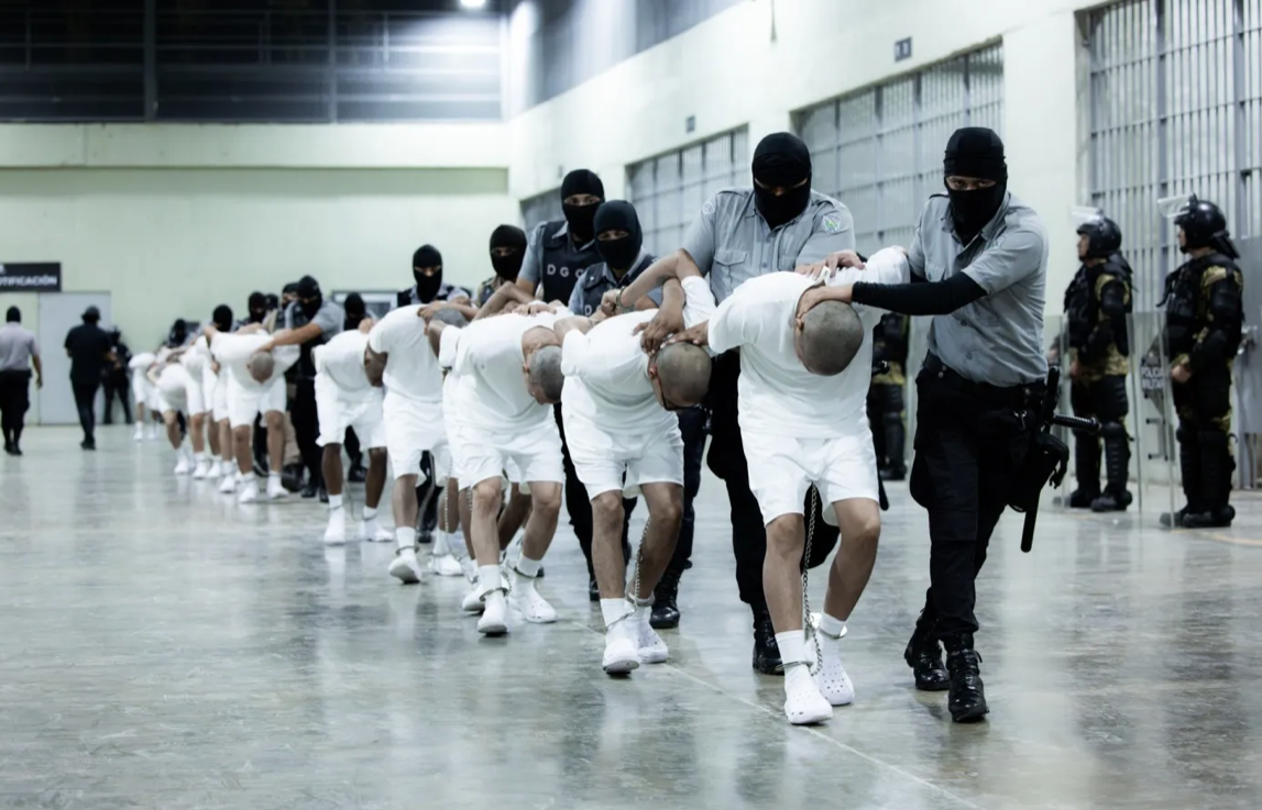 guards escorting inmates in white