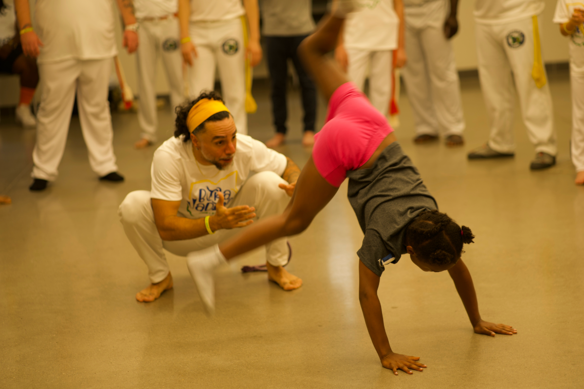 kid and man playing capoeira