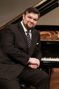 Luiz Guilherme Pozzi next to a piano