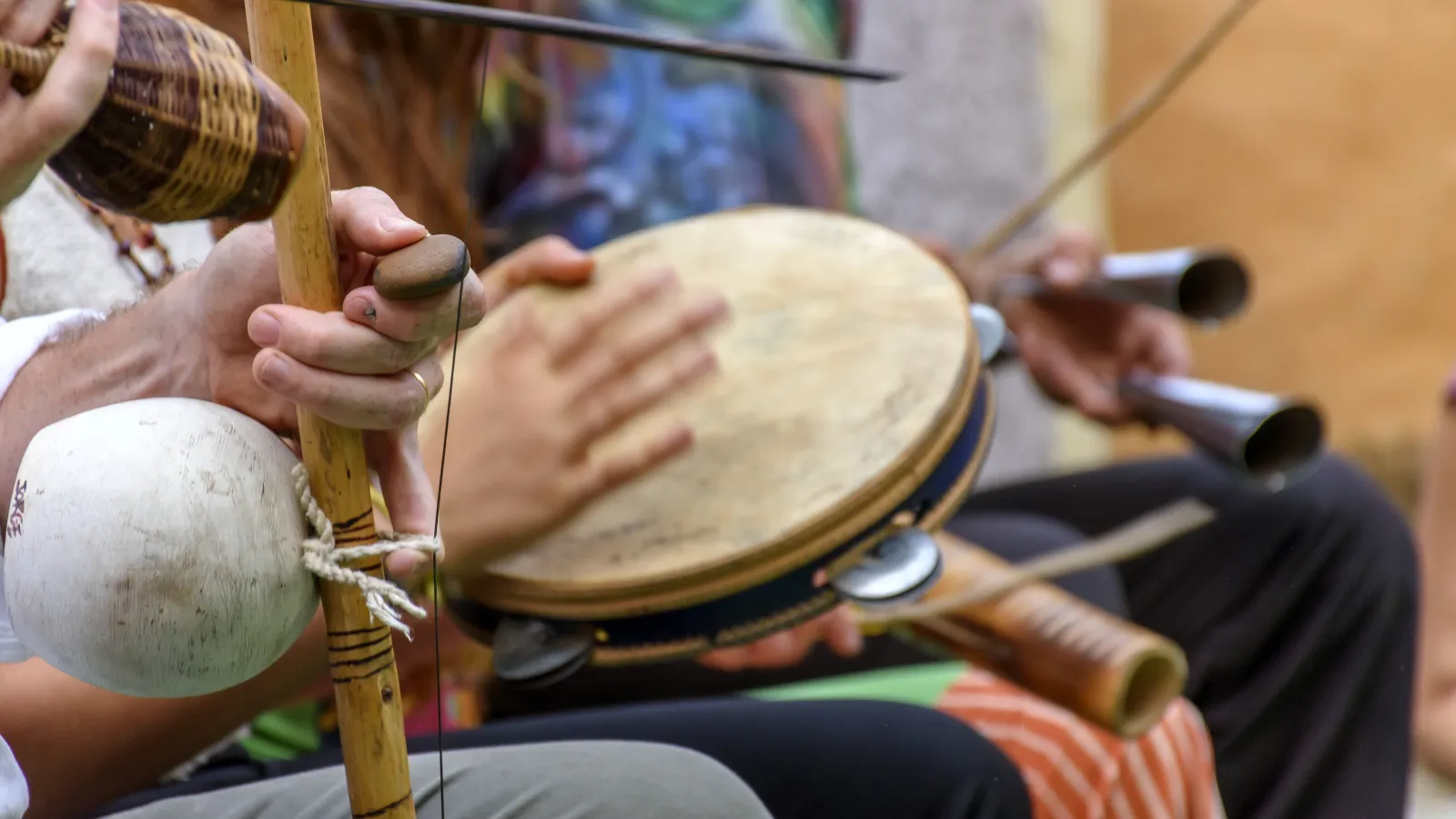 A group of people playing capoeira musical instruments