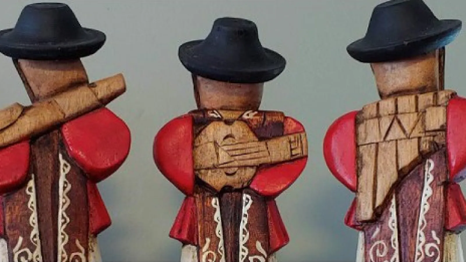 A figurine of three persons playing Andean musical instruments