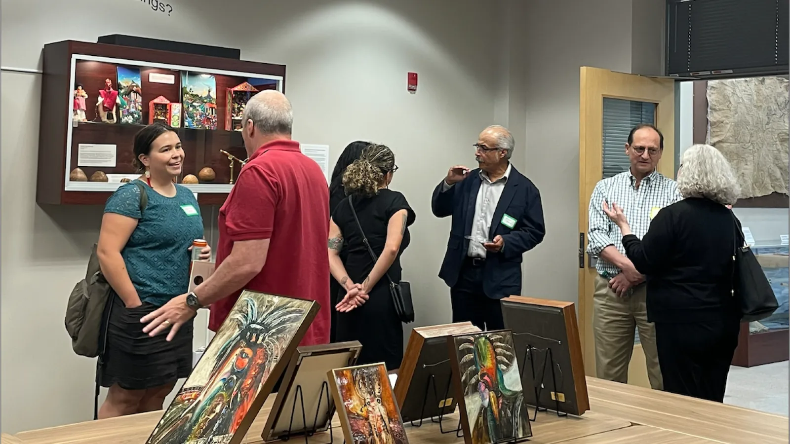 People talking and art work displayed on desks