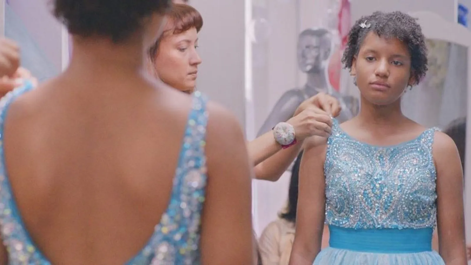 teenager in fancy dress looking in the mirror 