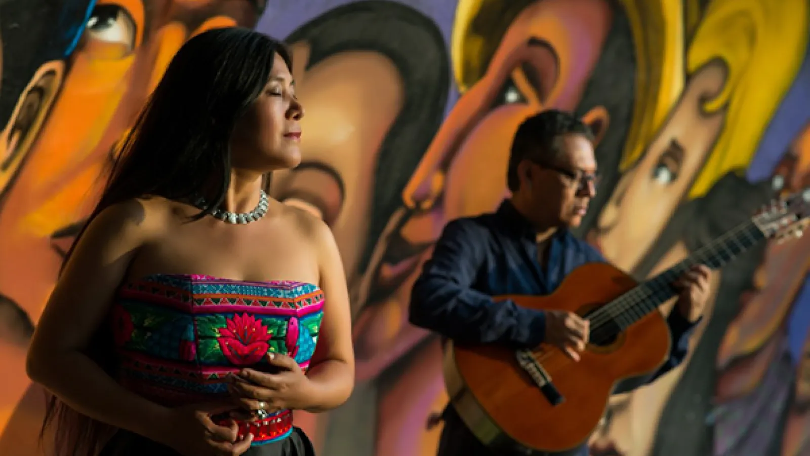 woman with a man in the background with a guitar