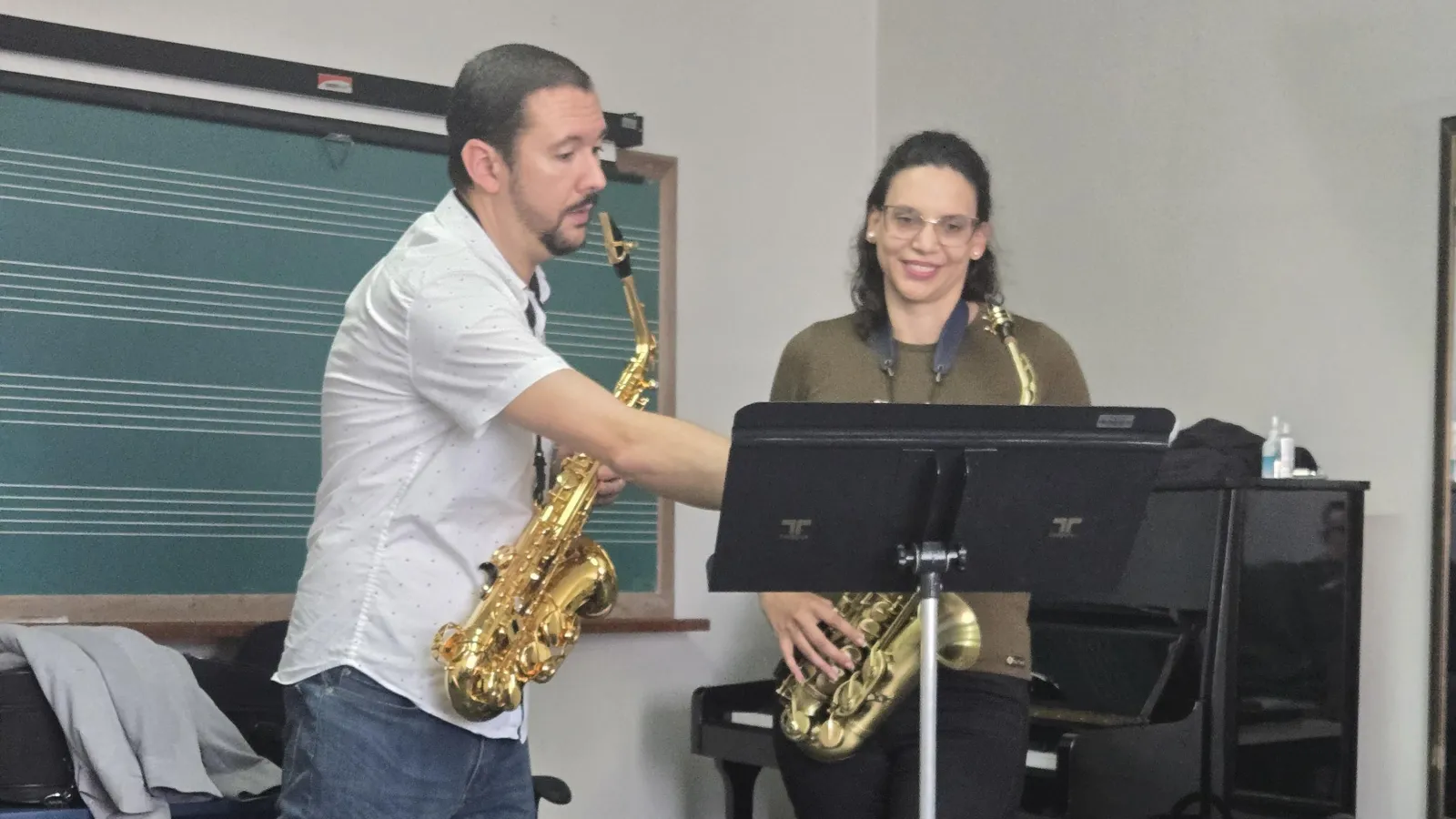 A Saxophone Professor signaling a music sheet sction to a student