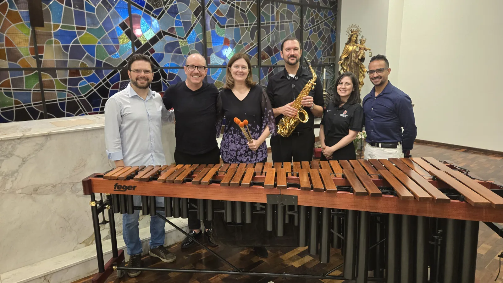 A group of people behind a Marimba