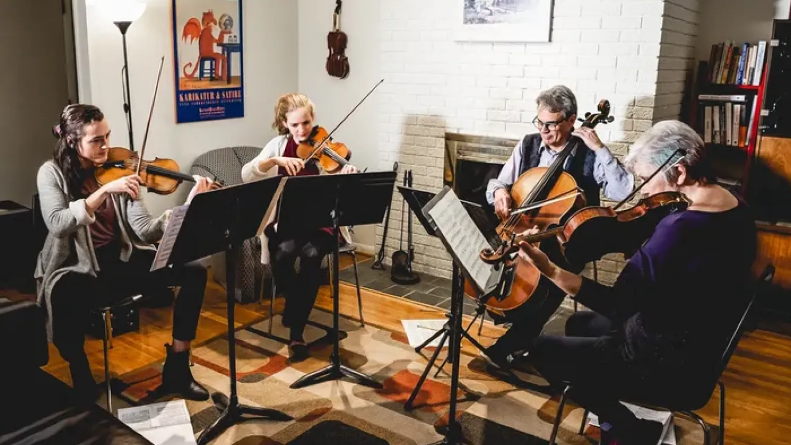 four people playing string instruments