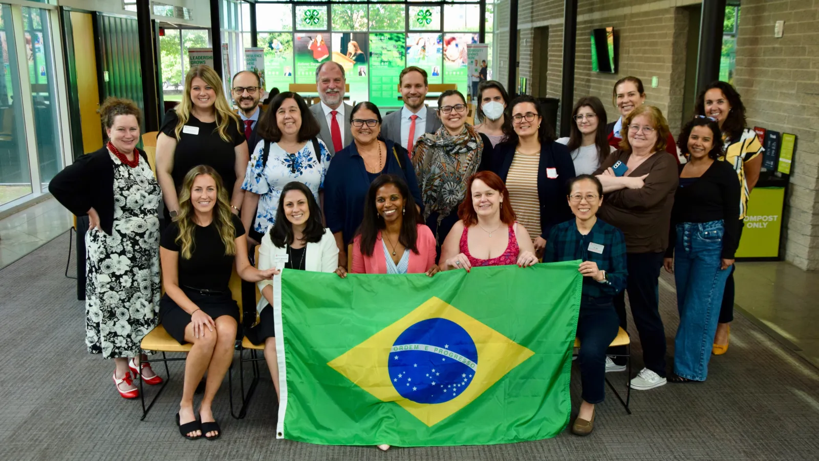 group of people behind a Brazilian flag