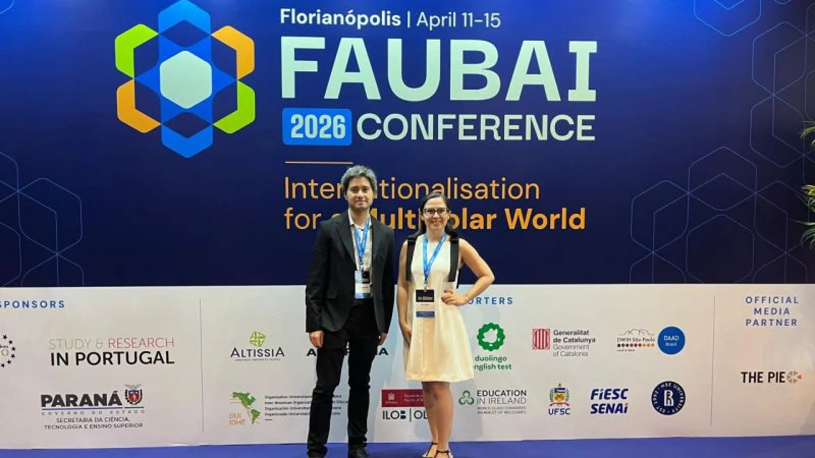 man and woman in front of sign that says FAUBAI