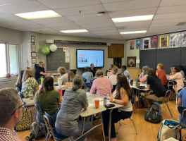 Julio playing talking in a room full of teachers