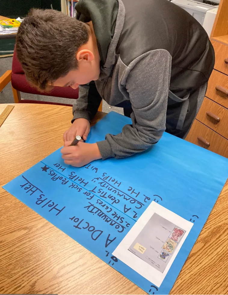 student writing on blue paper