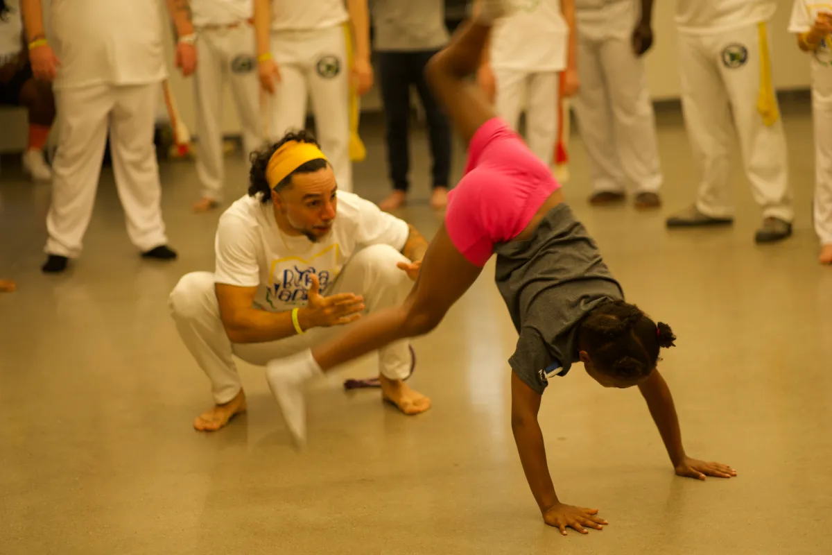 kid and man playing capoeira