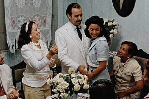 characters in a living room, woman hugging man