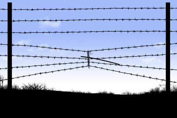 border fence on the southern border of the USA that has barbed wire compressed to make an opening underneath for an opening to cross into the USA