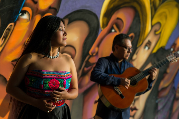 woman with a man in the background with a guitar