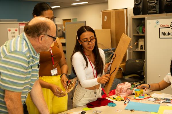 student showing cardboard to instructor