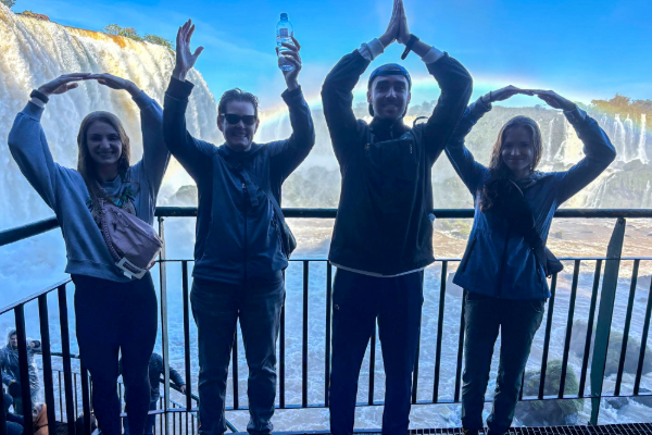 People standing in front of Iguazu Falls, spelling "OHIO" with their arms