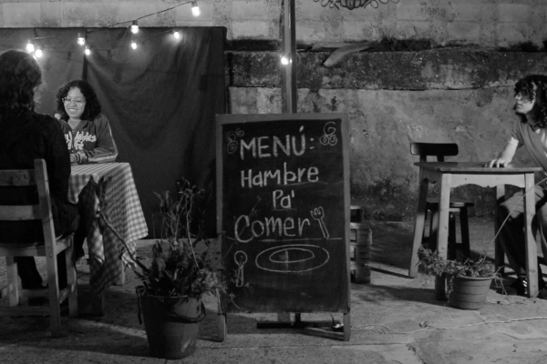 scene of film, restaurant; two people at one table in one corner, guy at another table in the other corner