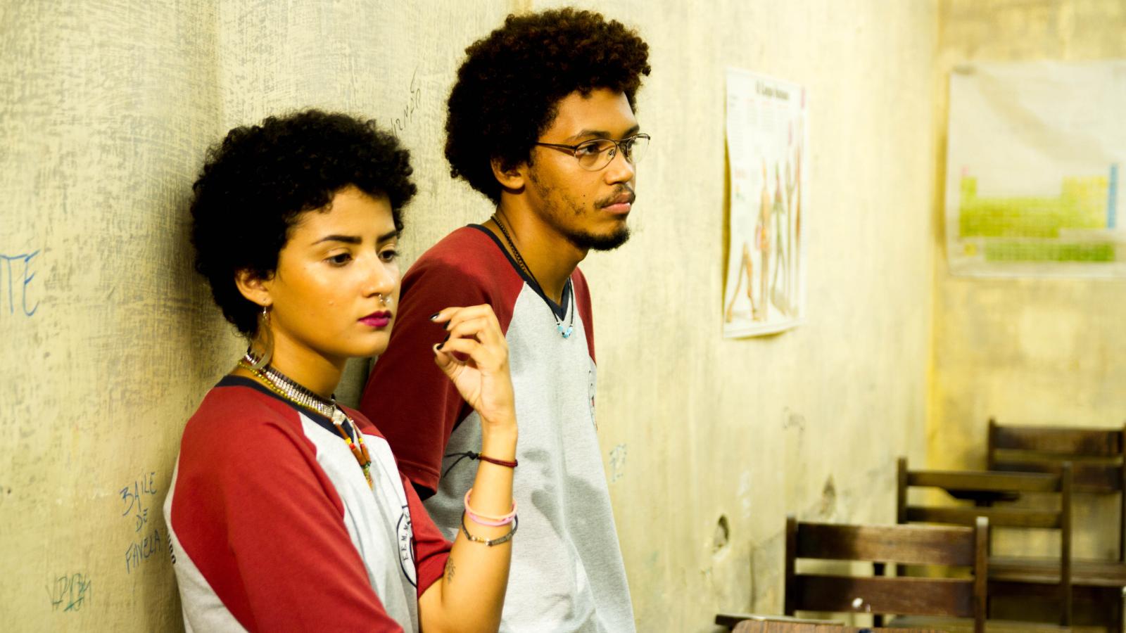 young woman and man leaning against wall