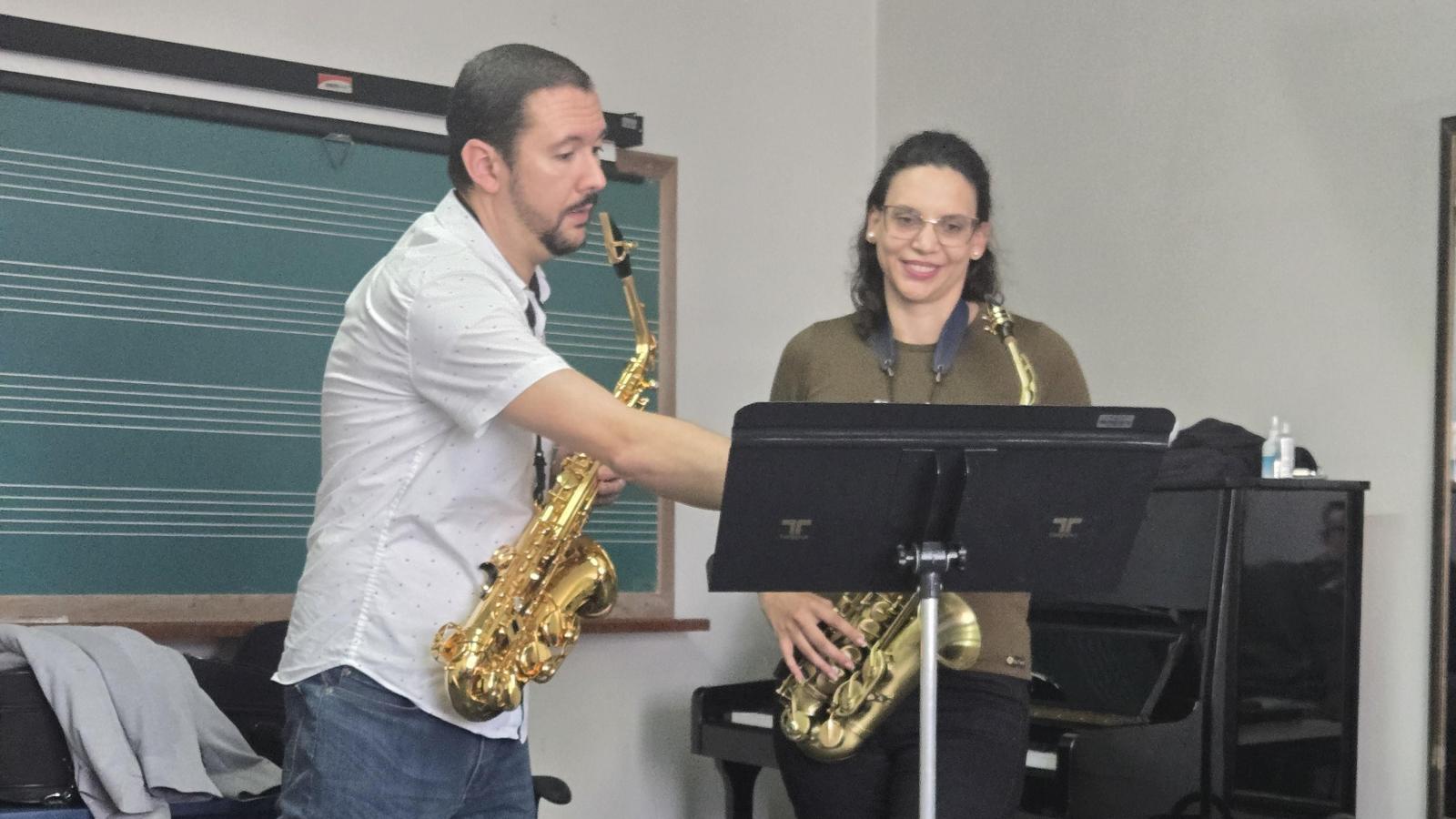 A Saxophone Professor signaling a music sheet sction to a student