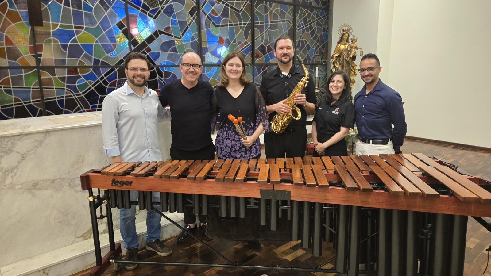 A group of people behind a Marimba