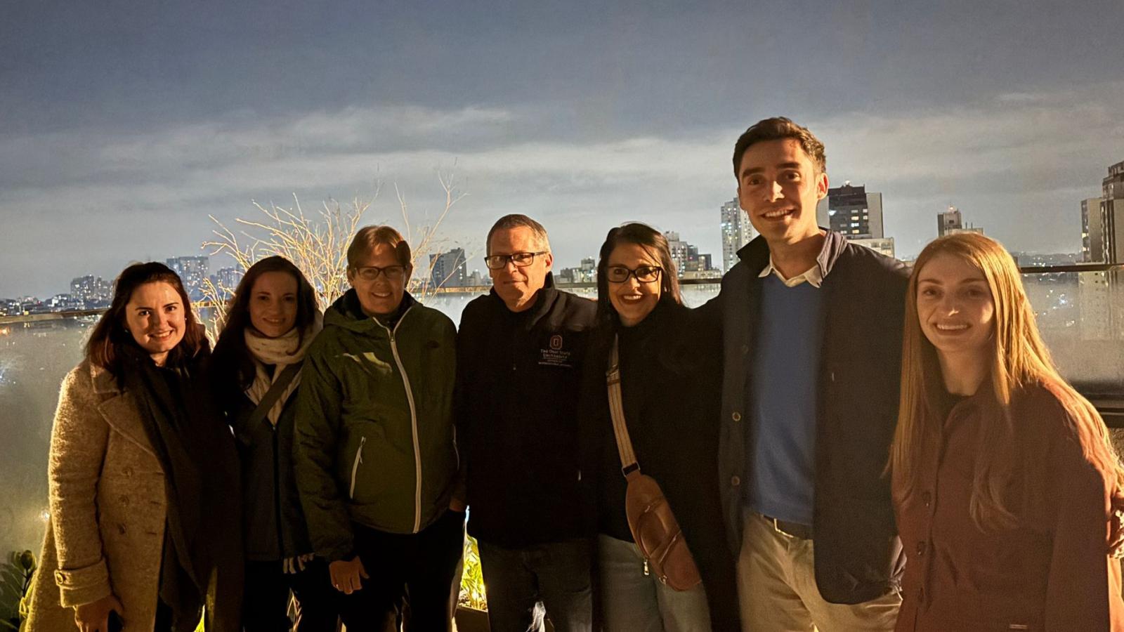 IPAST participants on a rooftop location in Curitiba with night skyline